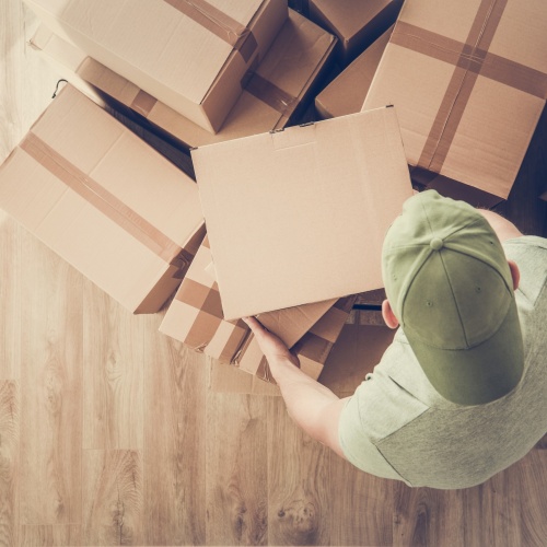 New Rental Apartment Moving In. Caucasian Men Carrying Cardboard Boxes with Personal Stuff.